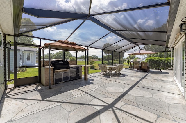 view of patio / terrace with glass enclosure, exterior kitchen, and outdoor dining area