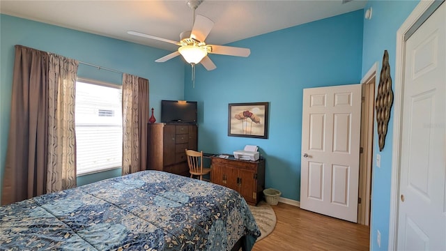 bedroom featuring baseboards, ceiling fan, and wood finished floors