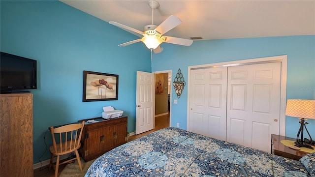 bedroom featuring a closet, baseboards, a ceiling fan, and vaulted ceiling
