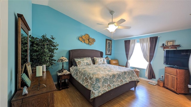 bedroom with a ceiling fan, baseboards, vaulted ceiling, and wood finished floors