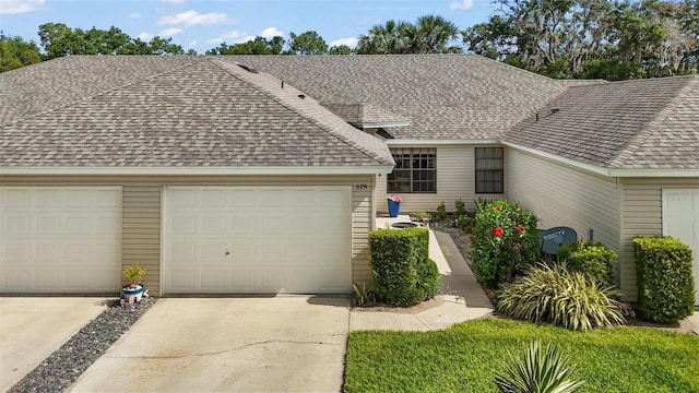 ranch-style house featuring a garage, a shingled roof, and driveway