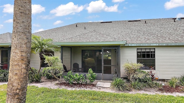 back of property featuring roof with shingles and a sunroom