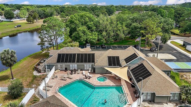 exterior space with a fenced backyard, a community hot tub, a patio area, and a water view