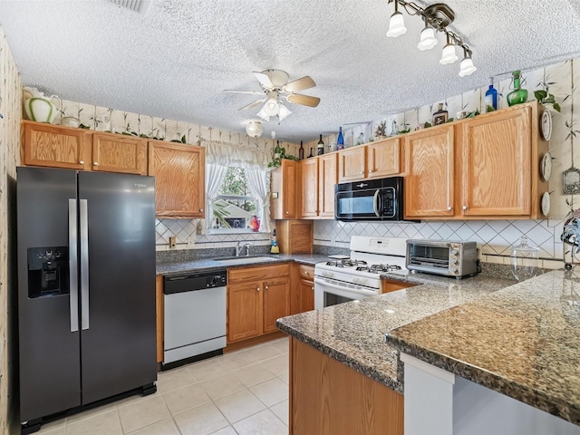 kitchen featuring black microwave, dishwasher, white range with gas stovetop, a toaster, and stainless steel refrigerator with ice dispenser