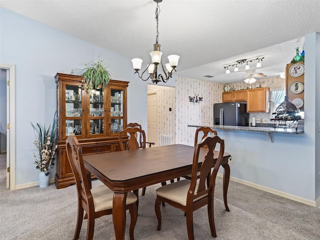 dining area featuring baseboards, light carpet, a textured ceiling, and a notable chandelier