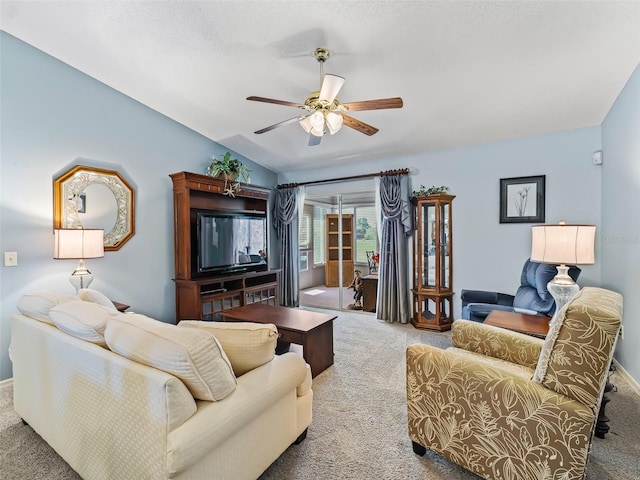 living area with baseboards, carpet, ceiling fan, and lofted ceiling
