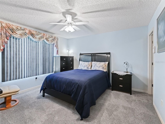 carpeted bedroom with baseboards, a ceiling fan, and a textured ceiling