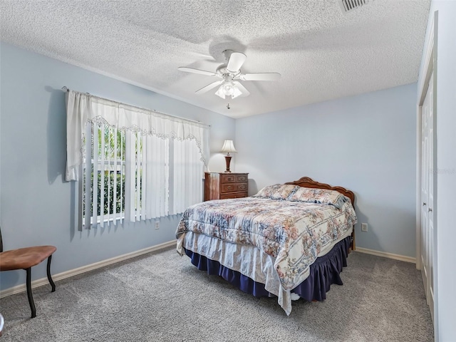 carpeted bedroom featuring baseboards, ceiling fan, a textured ceiling, and visible vents