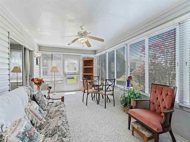 sunroom / solarium with plenty of natural light, a textured ceiling, and carpet