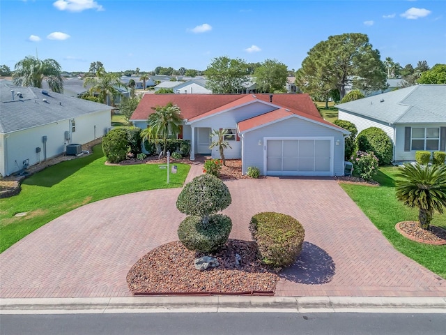 view of front of house with decorative driveway, cooling unit, a residential view, and a front lawn