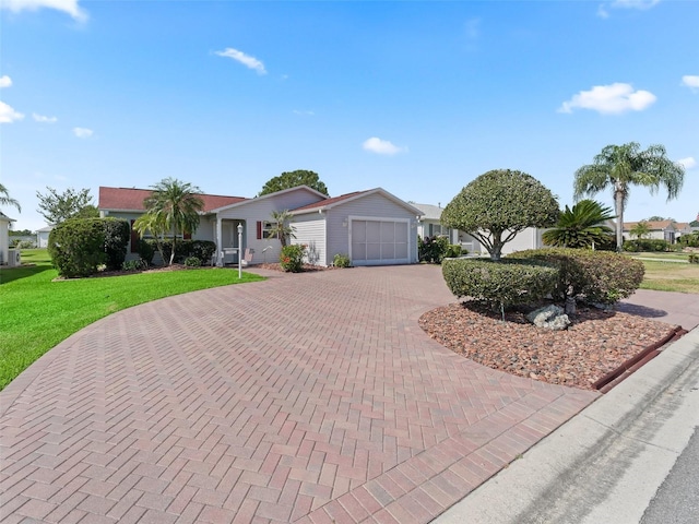 single story home featuring curved driveway, a garage, and a front lawn