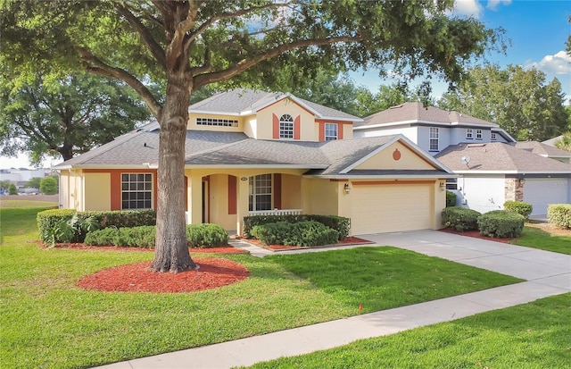 traditional home featuring driveway, stucco siding, an attached garage, and a front yard