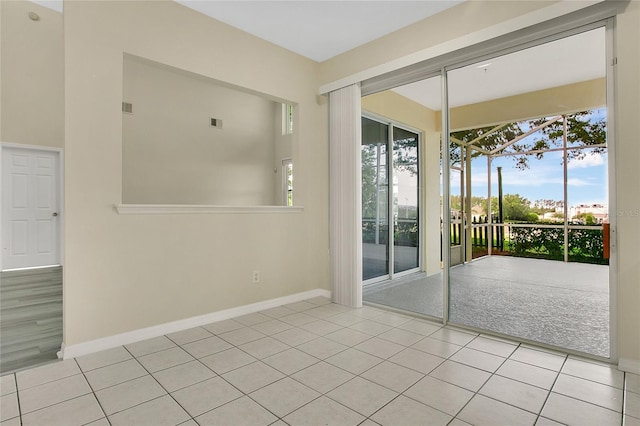 doorway featuring baseboards, tile patterned floors, a healthy amount of sunlight, and visible vents