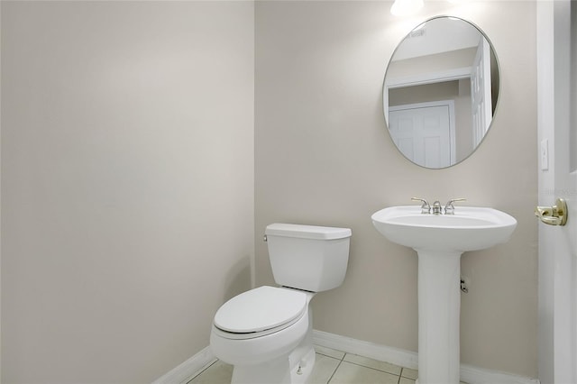 half bath featuring toilet, tile patterned flooring, and baseboards