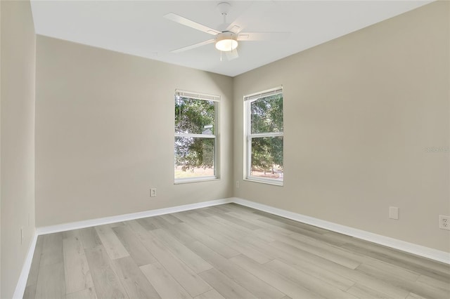 spare room with light wood finished floors, baseboards, and ceiling fan
