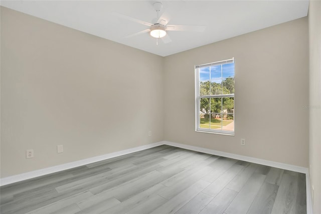 spare room with baseboards, a ceiling fan, and wood finished floors