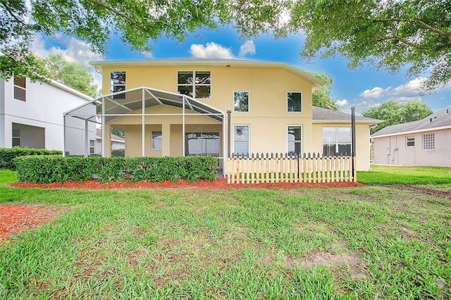 back of house with a lawn, stucco siding, and a lanai