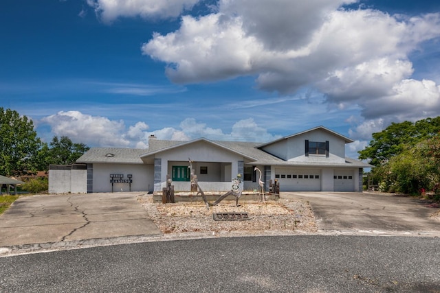 view of front of house with a shingled roof and concrete driveway