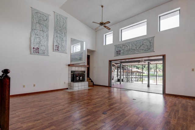 unfurnished living room featuring a ceiling fan, wood finished floors, a healthy amount of sunlight, and high vaulted ceiling