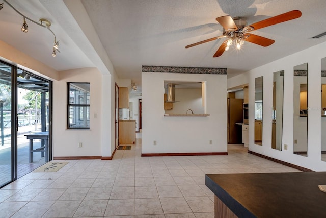 foyer featuring baseboards, ceiling fan, visible vents, and light tile patterned floors