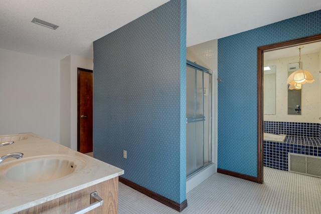 full bathroom featuring a sink, tile patterned floors, wallpapered walls, and visible vents