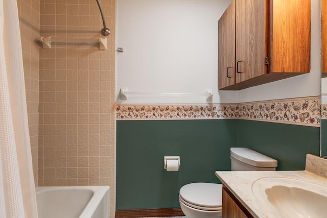 bathroom featuring vanity, a wainscoted wall, toilet, and shower / bath combo with shower curtain