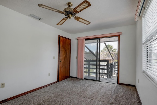 carpeted spare room featuring baseboards, ceiling fan, and visible vents