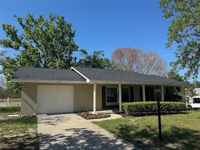 ranch-style house featuring an attached garage, concrete block siding, fence, and concrete driveway