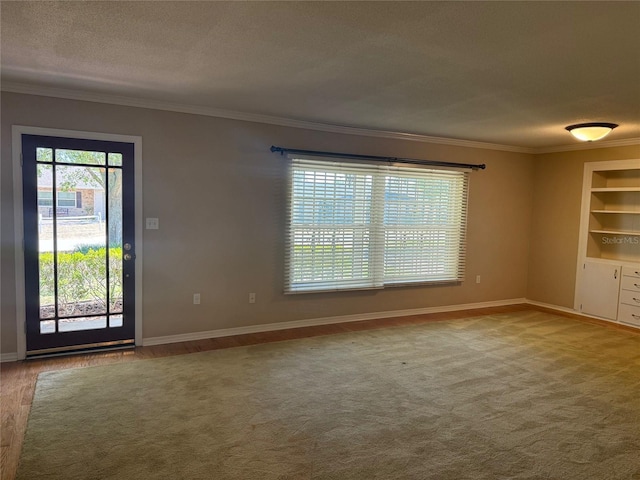 empty room featuring baseboards, ornamental molding, and built in shelves