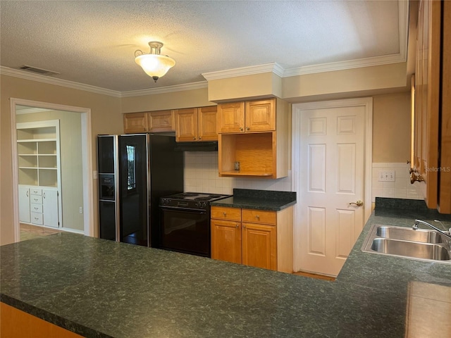 kitchen featuring visible vents, under cabinet range hood, a sink, backsplash, and black appliances