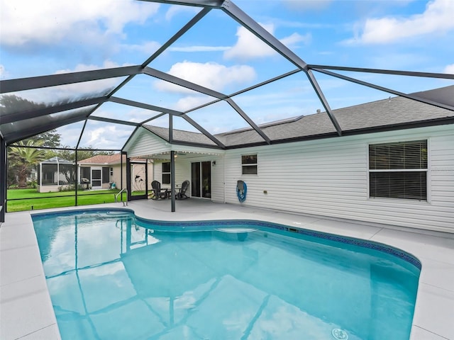 pool with a patio, a yard, and glass enclosure