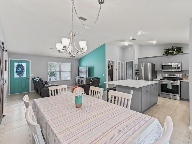dining room with light tile patterned floors, visible vents, lofted ceiling, and a chandelier