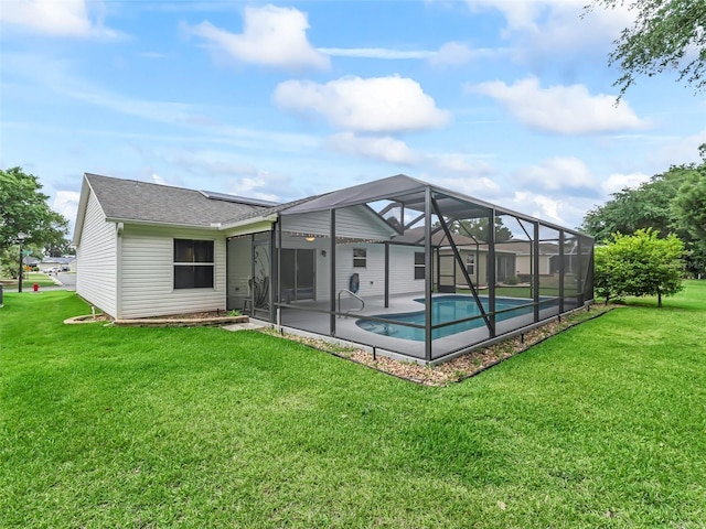 back of property featuring a patio, an outdoor pool, roof with shingles, a lawn, and a lanai