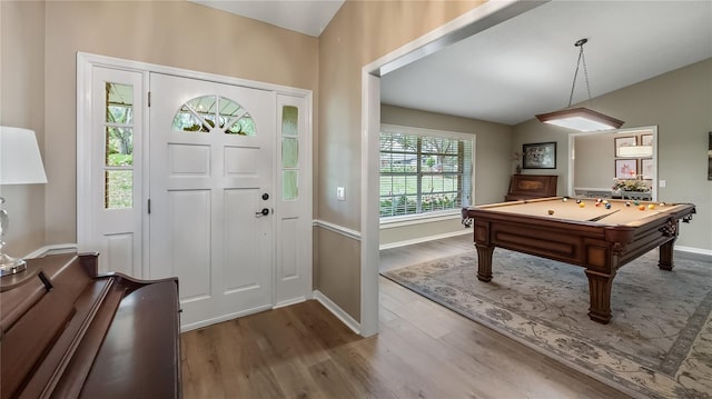 foyer featuring billiards, baseboards, vaulted ceiling, and wood finished floors