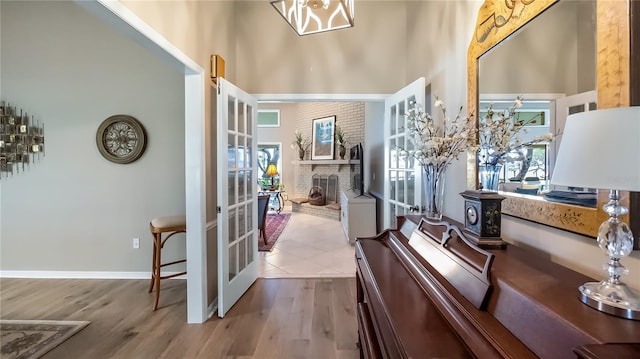 interior space with plenty of natural light, a high ceiling, french doors, and wood finished floors