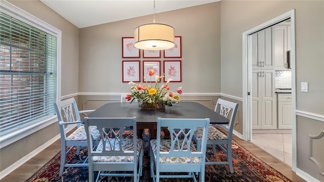 dining space featuring a healthy amount of sunlight, wainscoting, and wood finished floors