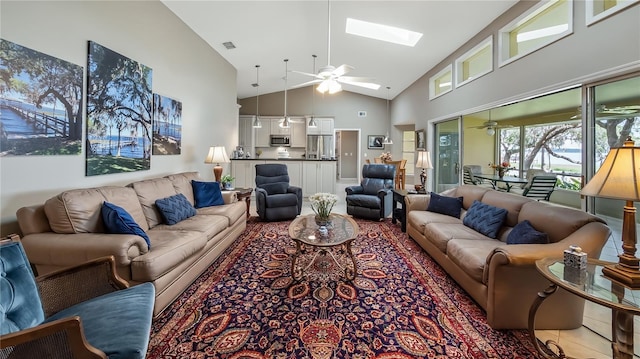 tiled living area with a skylight, high vaulted ceiling, a ceiling fan, and visible vents