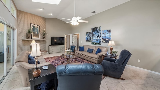 living area with a ceiling fan, visible vents, a skylight, light tile patterned floors, and high vaulted ceiling