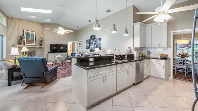 kitchen with ceiling fan, a sink, dishwasher, high vaulted ceiling, and a peninsula