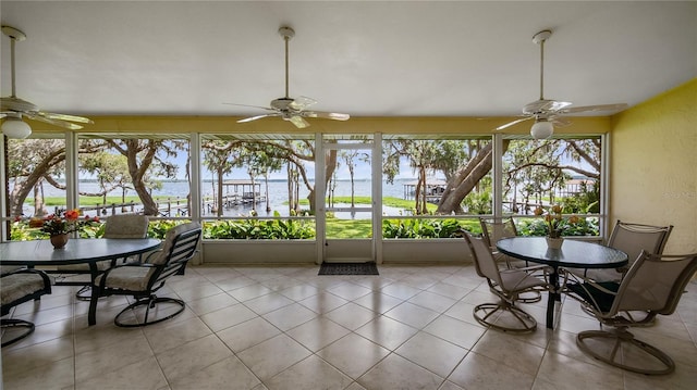 sunroom / solarium with a water view and tile patterned floors