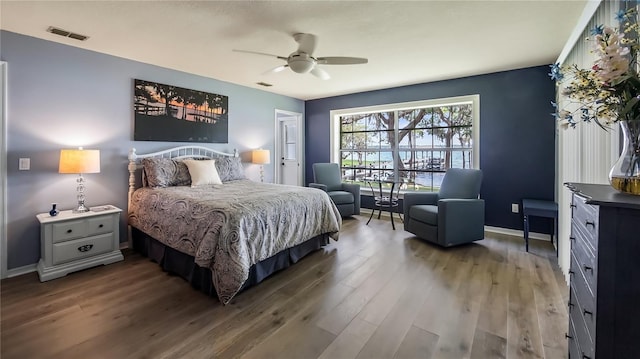 bedroom featuring baseboards, ceiling fan, visible vents, and wood finished floors