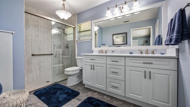 bathroom with double vanity, a sink, toilet, and a shower stall