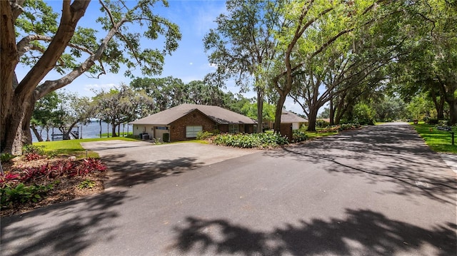 exterior space featuring a water view and aphalt driveway