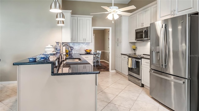 12104 Elbert St, Clermont, FL 34711 - kitchen featuring appliances with stainless steel finishes, dark countertops, ceiling fan, white cabinetry, and tasteful backsplash
