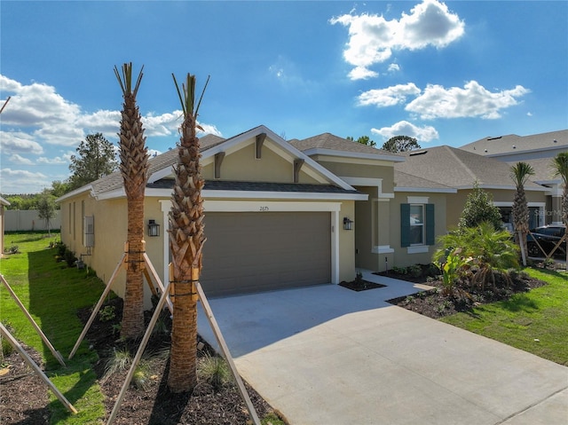 view of front of house with stucco siding, an attached garage, concrete driveway, a shingled roof, and a front yard