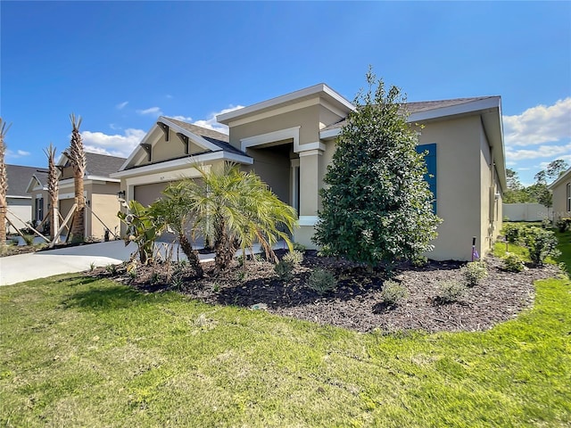 view of front of property featuring stucco siding, a front lawn, a garage, and driveway