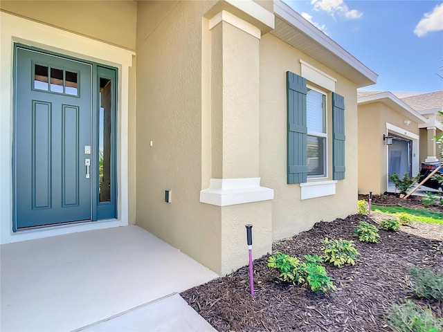 view of exterior entry featuring stucco siding