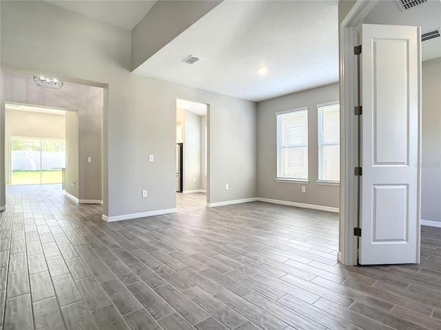 spare room with baseboards and wood tiled floors