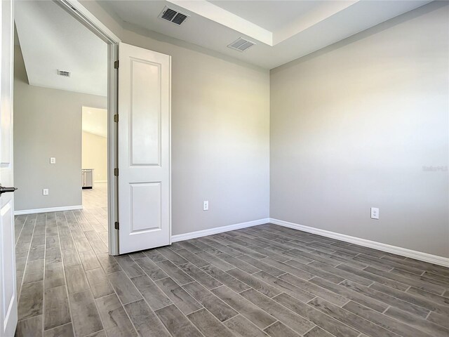 empty room featuring dark wood-type flooring and baseboards