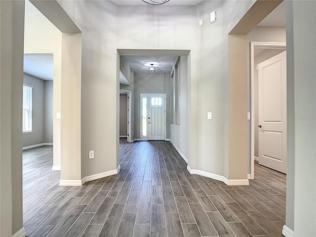foyer with dark wood finished floors and baseboards
